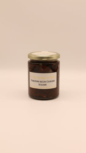 Die Conserve conti Pomodori Secchi Ciliegino - 270 g mit sonnengetrockneten sizilianischen Kirschtomaten in Olivenöl wird in einem Glas mit goldenem Deckel vor einem schlichten beigen Hintergrund präsentiert.