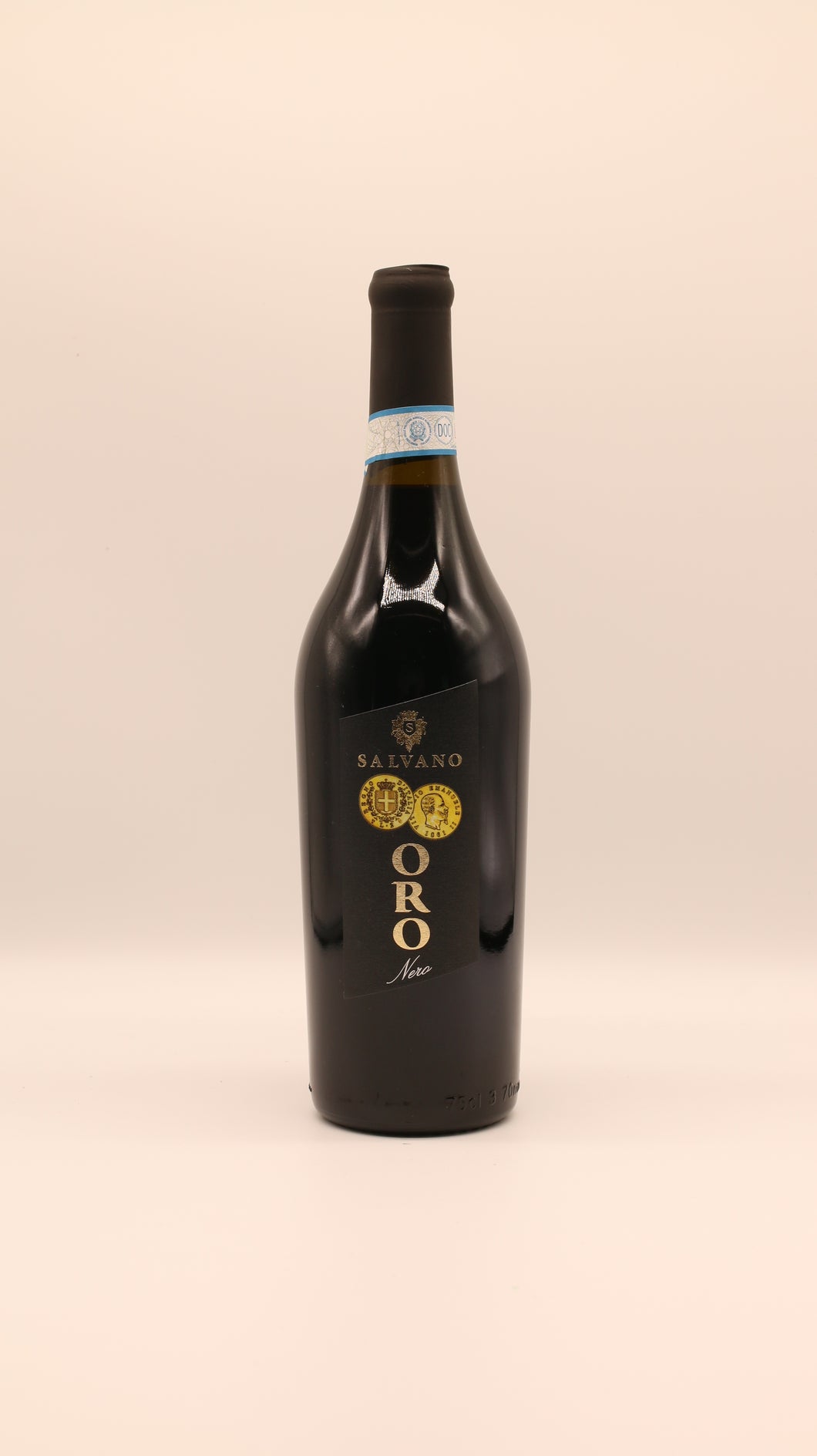 Eine Flasche Salvano ORO NERO 2020 DOC 0,75L mit schwarz-goldenem Etikett, schwarzem Folienverschluss und hellblauem Halsband steht vor einem schlichten, hellen Hintergrund.