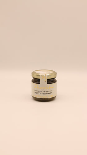 Ein kleines Glas mit goldenem Deckel mit Conserve conti Condimento per Pasta con Broccoli 