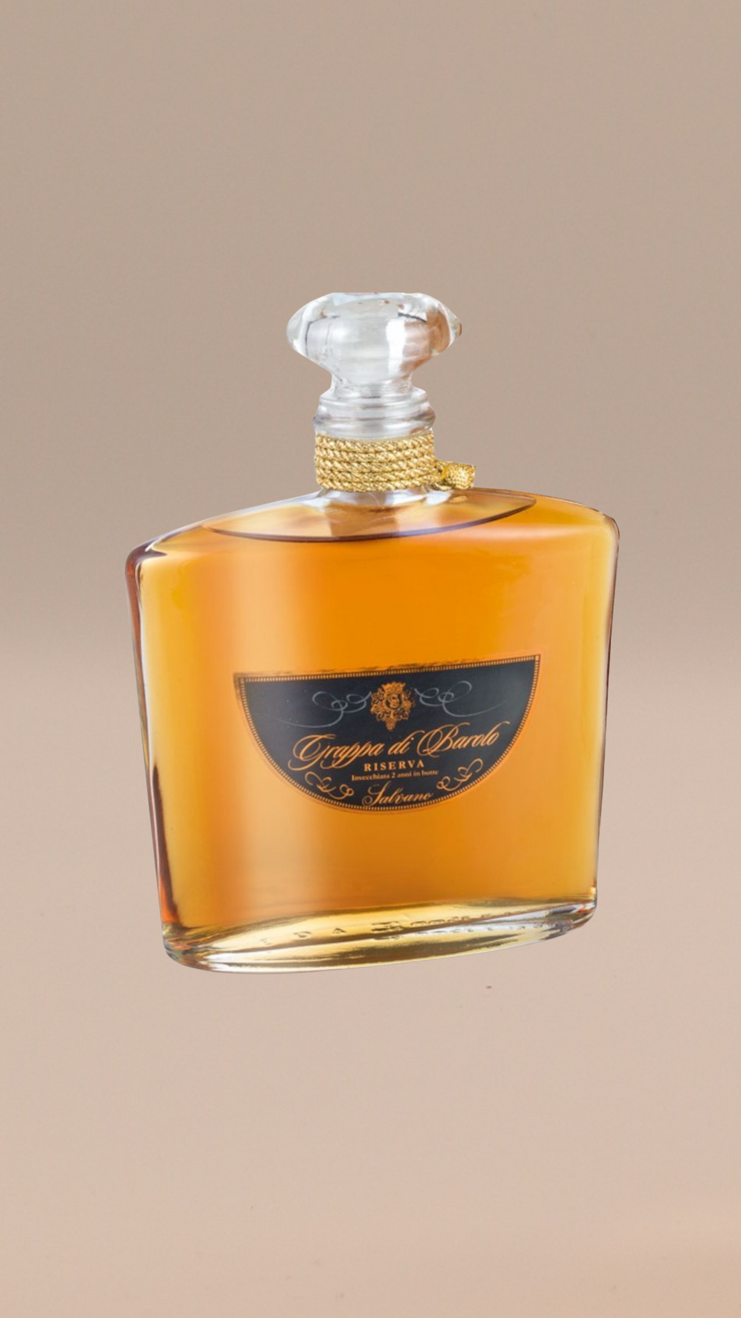 Eine klare, elegante Glasflasche von salvano GRAPPA DI BAROLO RISERVA 0,7 / 1,5 Liter mit bernsteinfarbener Flüssigkeit, einem goldfarbenen Etikett und einem mit Gold umwickelten Hals hebt sein reiches Erbe vor einem neutralen beigen Hintergrund hervor.