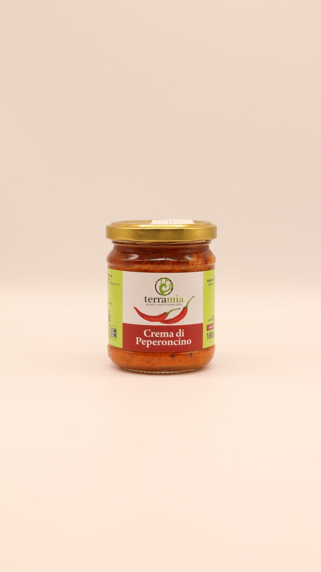 Ein Glas Terramia Patè di Peperoncino (180 g) mit goldenem Deckel, gefüllt mit roter Chilicreme, steht vor einem schlichten hellbeigen Hintergrund.