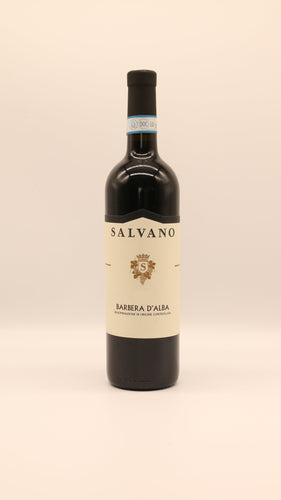 Eine Flasche Salvano BARBERA ALBA 2021 DOC 0,75 Liter mit cremefarbenem Etikett, goldenem Wappen und schwarzem Text steht aufrecht vor einem hellen, neutralen Hintergrund.