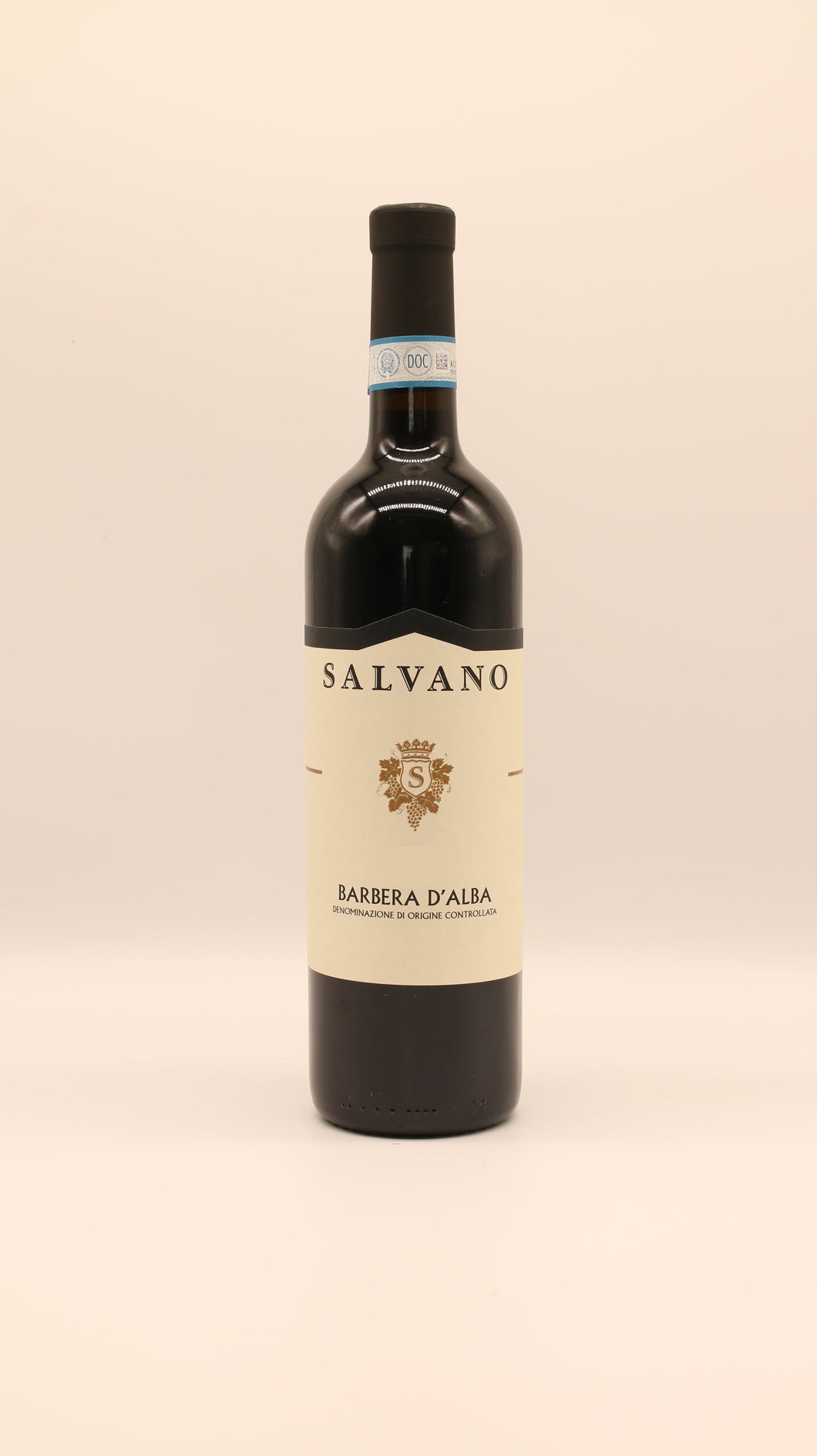 Eine Flasche Salvano BARBERA ALBA 2021 DOC 0,75 Liter mit cremefarbenem Etikett, goldenem Wappen und schwarzem Text steht aufrecht vor einem hellen, neutralen Hintergrund.