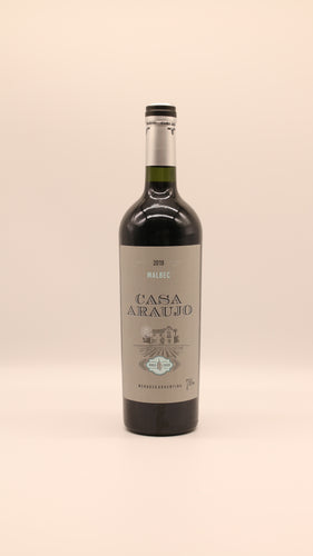 Eine Flasche Malbec Roble Casck 2019 (0,75 l) von Bodega Araujo, Argentinien, steht aufrecht vor einem schlichten, hellen Hintergrund. Das Etikett zeigt eine Illustration des Hauses mit türkisfarbenen Akzenten und hebt die Herkunft aus Mendoza hervor.