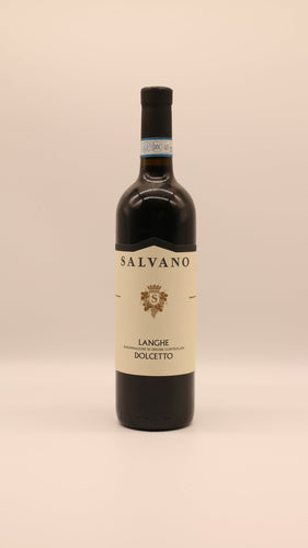 Eine Flasche Salvano LANGHE DOLCETTO 2019 DOC 0,75 Liter mit cremefarbenem Etikett und blau akzentuiertem Halsverschluss steht vor einem hellen Hintergrund.