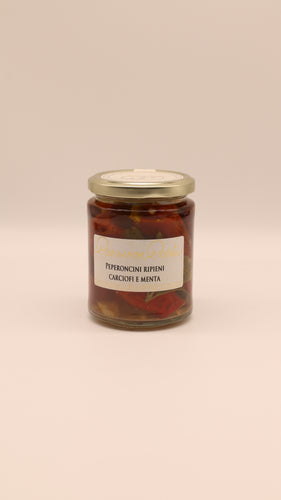 Ein Glasgefäß mit goldenem Deckel enthält Conserve Conti Peperoncini ripieni carciofi e menta (270 g), eine sizilianische vegane Antipasti-Spezialität, die auf einem schlichten hellen Hintergrund abgebildet ist.