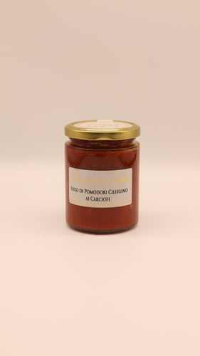 Ein 270-g-Glas mit Conserve Conti Sugo di Pomodori Ciliegino al Carciofi mit sizilianischer Kirschtomaten- und Artischockensauce und einem goldenen Deckel steht auf einem hellbeigen Hintergrund.