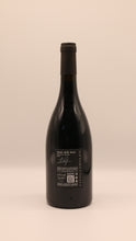 Lade das Bild in den Galerie-Viewer, Eine dunkle Glasflasche des Nino Gandolfo Monte delle Rose Le Contrade IGT 2022 steht aufrecht, das schwarze Etikett und die Folie heben sich von einem hellbeigen Hintergrund ab - ein eleganter Rotwein aus Sizilien mit charakteristischen Details.
