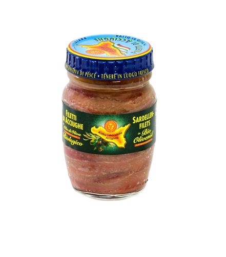 Das 90-g-Glas mit den Sardellenfilets von Pesce Azzurro Srl in Bio-Olivenöl extra vergine ist mit einem blauen Deckel, einem grünen Etikett, italienischem Text und Abbildungen von Fischen und Olivenzweigen versehen, die auf die traditionelle sizilianische Herkunft hinweisen.