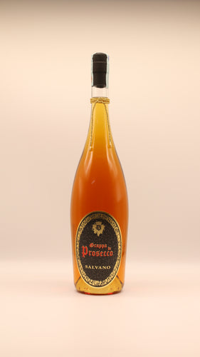 Eine Flasche Salvano GRAPPA DI PROSECCO BARRICATA (0,5l/1,5l) mit bernsteinfarbener Flüssigkeit, goldenem und schwarzem Etikett und einer goldenen Kordel um den Hals vor einem schlichten hellen Hintergrund - ideal für alle, die Grappa kaufen möchten.